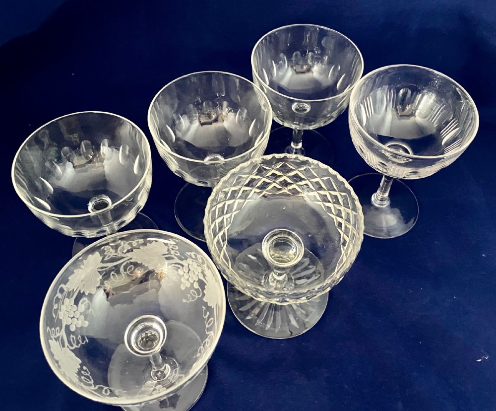 A set of six clear Edwardian stemware champagne coupes with assorted hand-cut and etched decorative patterns. View III