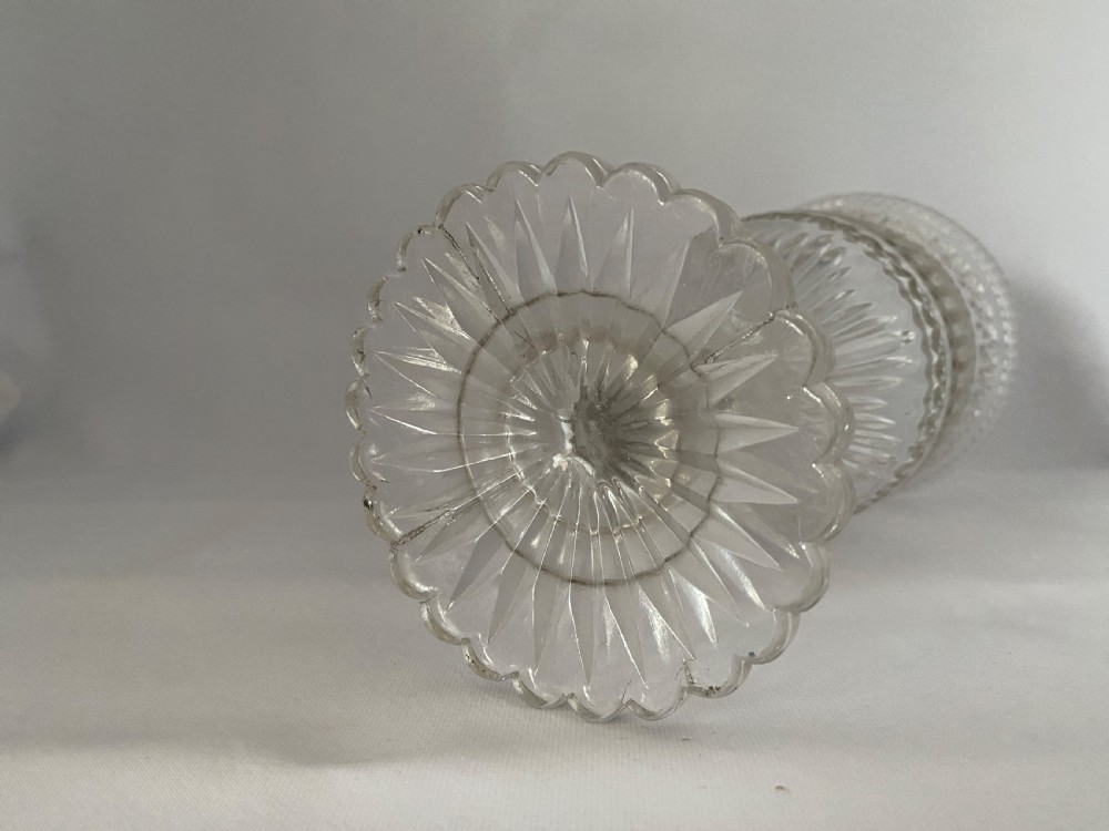 A clear glass Victorian celery vase featuring flared rim, diamond cut bands, a Greek key motif, and a scalloped circular pedestal foot. View III