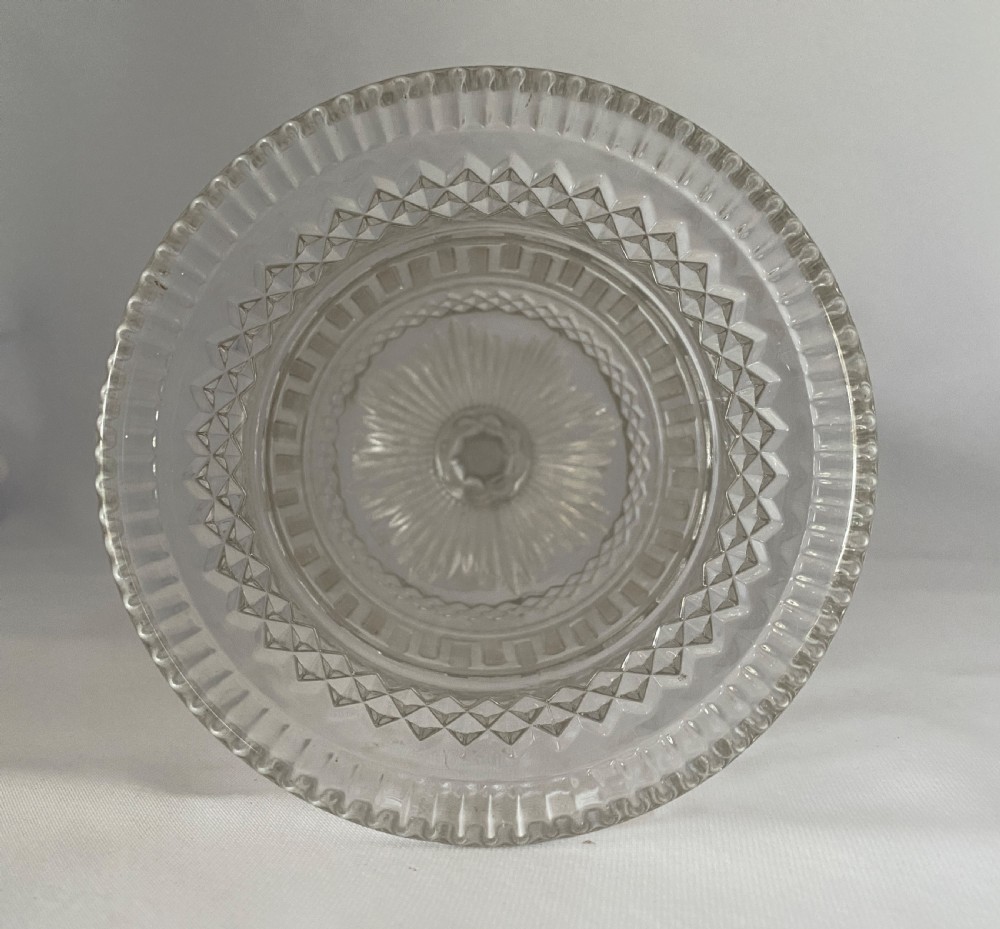 A clear glass Victorian celery vase featuring flared rim, diamond cut bands, a Greek key motif, and a scalloped circular pedestal foot. View V