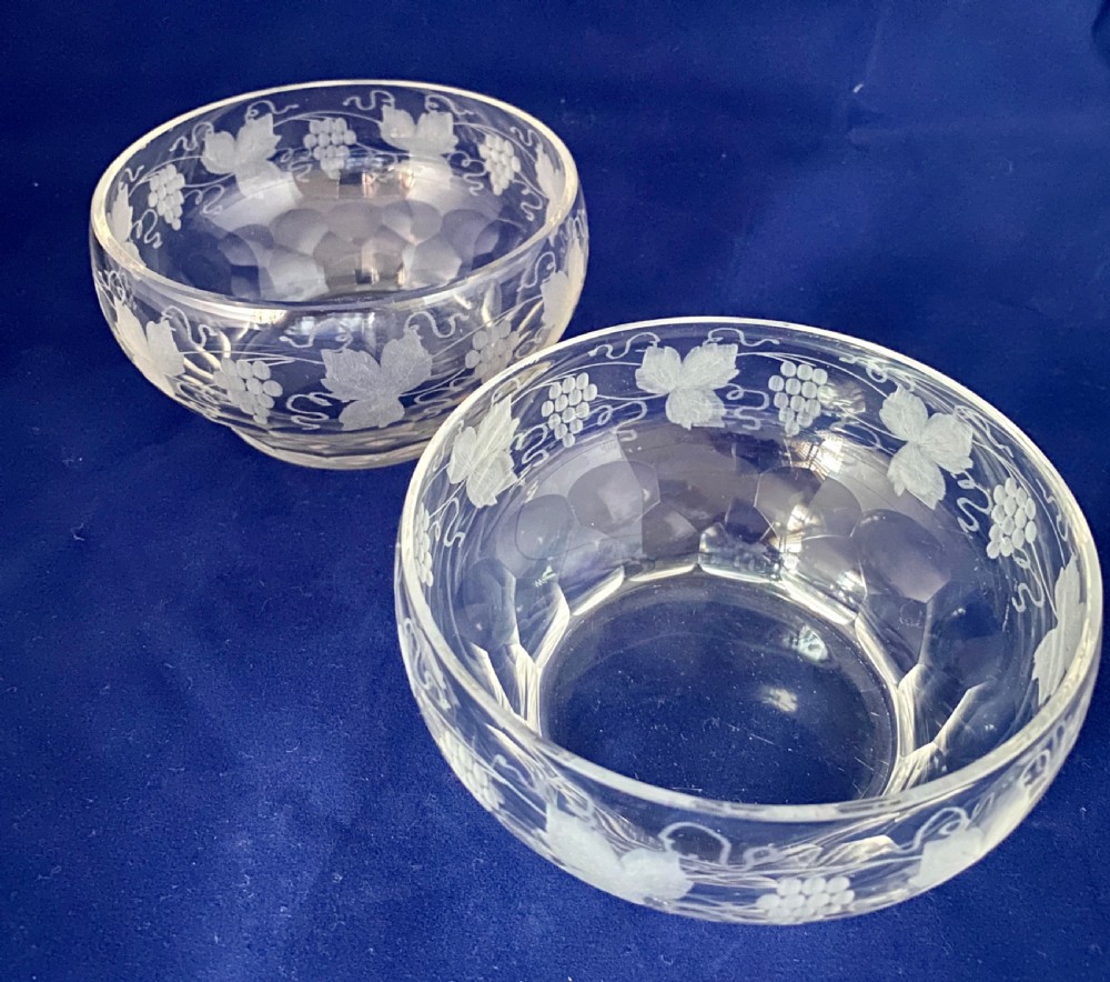 A pair of clear Victorian glass finger bowls with etched grape and vine motifs around the body and faceted cutting near the lower base. View II