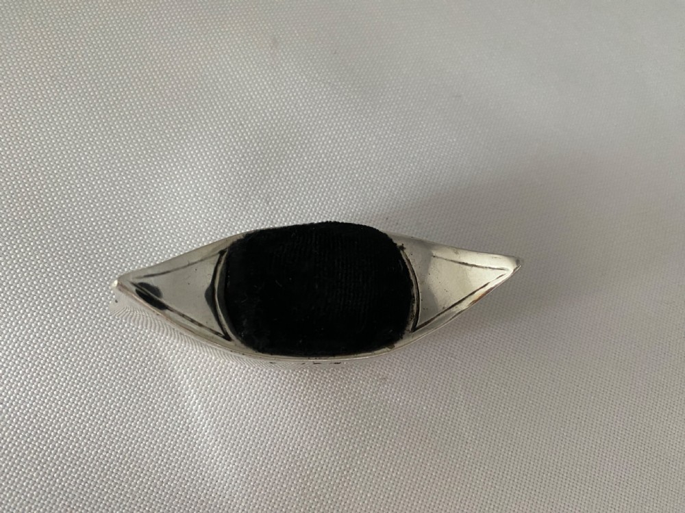 An Edwardian sterling silver pin cushion crafted in the shape of a canoe with a dark velvet insert and visible hallmarks on the exterior side. View II
