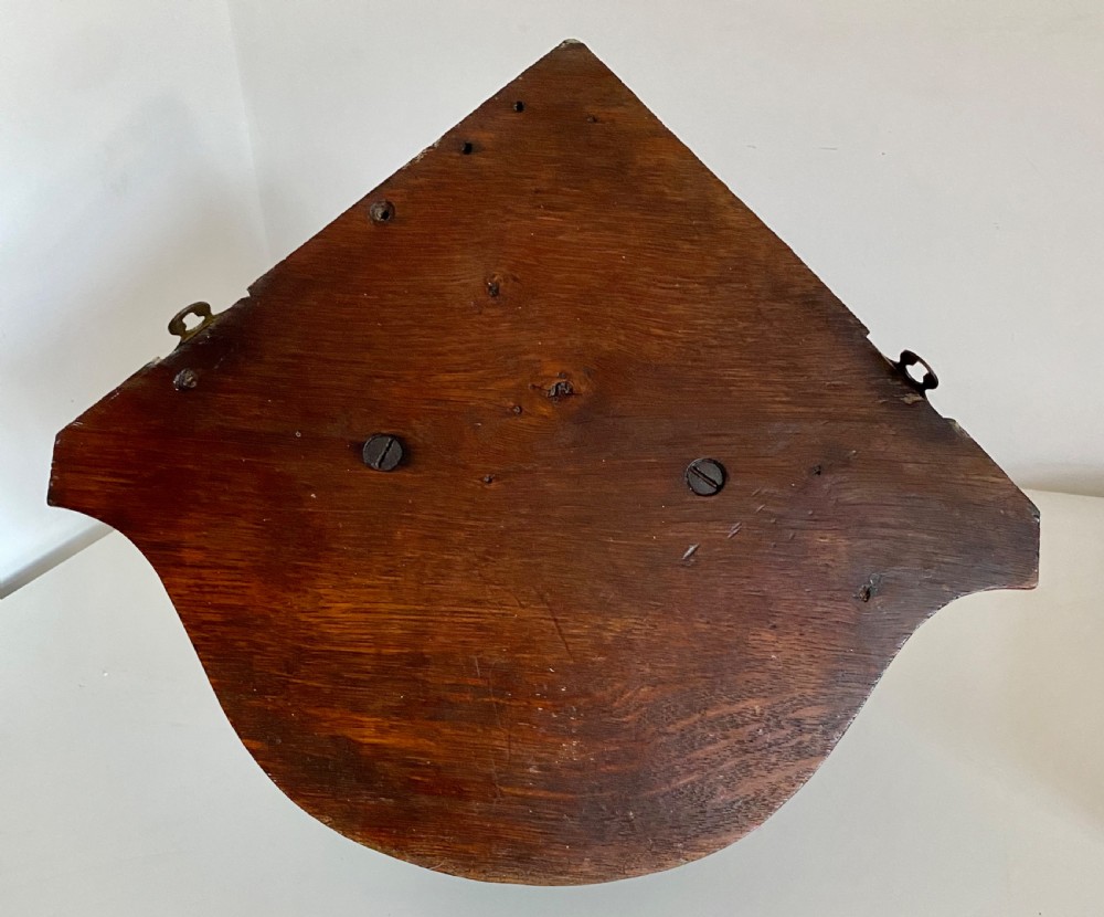 A Victorian carved oak corner bracket featuring a high-relief carved dog head surrounded by oak leaves and acorns beneath a curved corner shelf. View VII