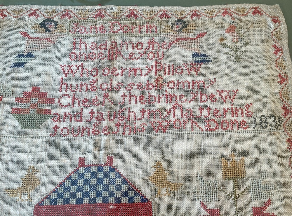 A framed 1839 Victorian needlework sampler featuring an embroidered verse, central house motif, floral trees, and the name Jane Dorrin on natural linen. View II