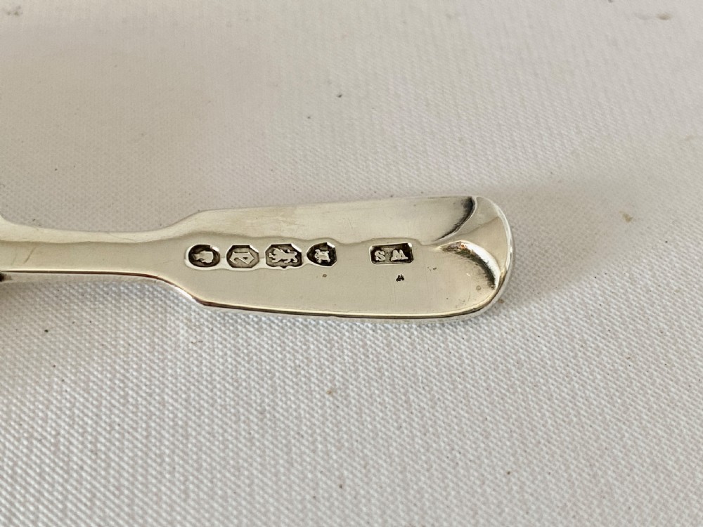 A Victorian sterling silver caddy spoon featuring a flared shovel-shaped bowl and a short handle engraved with a monogram. View VI