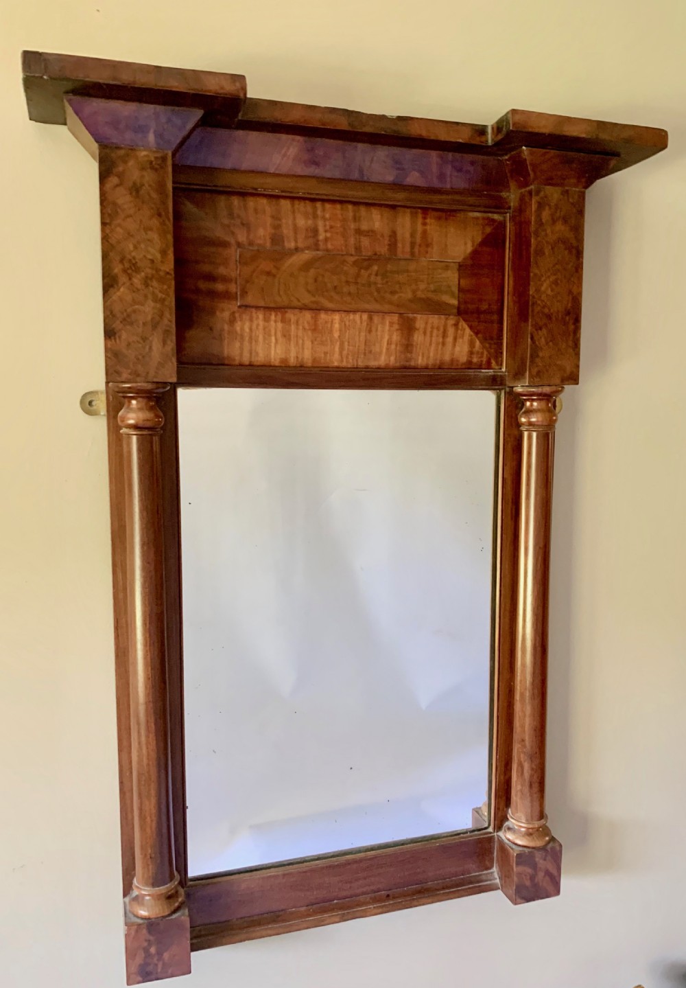 A Regency mahogany pier mirror featuring an upper frieze with flame mahogany veneer, flanked by turned half-columns and topped with a projecting cornice. View V