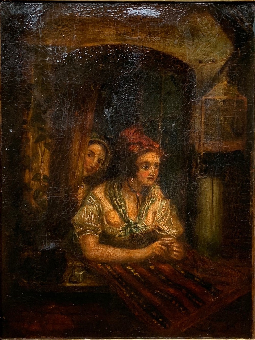 A 19th-century oil painting on canvas illustrating two figures in period dress within a dimly lit interior displaying craquelure throughout.
