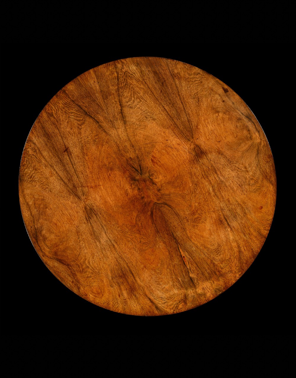 A George IV rosewood occasional table with a circular top, turned central pedestal stem, and a triform base with carved feet. View II