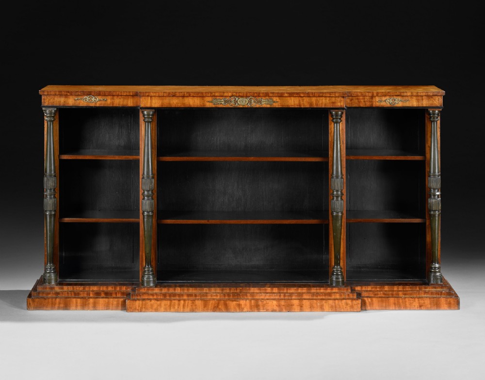 A low Regency breakfront open bookcase crafted from warm brown mahogany with turned columns and decorative brass mounts. View II
