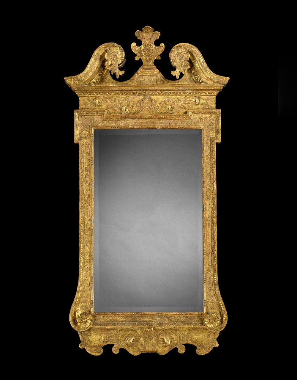 A George II gilt-wood and gesso pier mirror featuring a carved swan-neck pediment, a central cartouche, and rectangular mirror plate surrounded by foliate detailing.