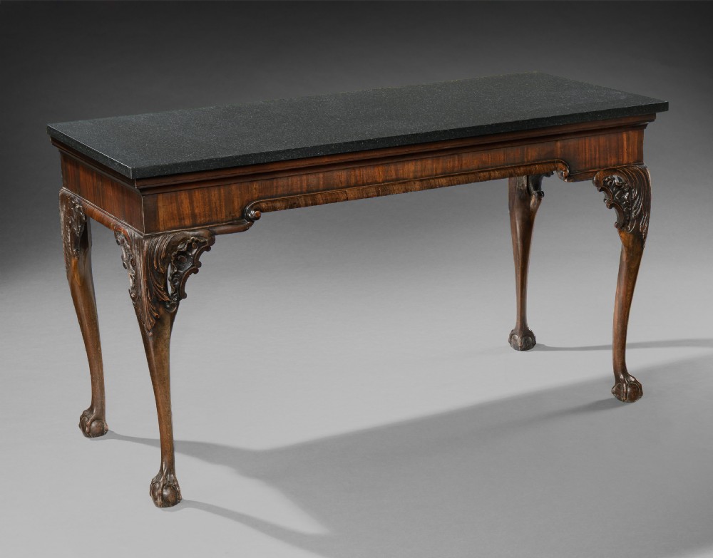 A George II mahogany side table featuring a dark rectangular stone top set above hand-carved cabriole legs with acanthus foliage knees. View II