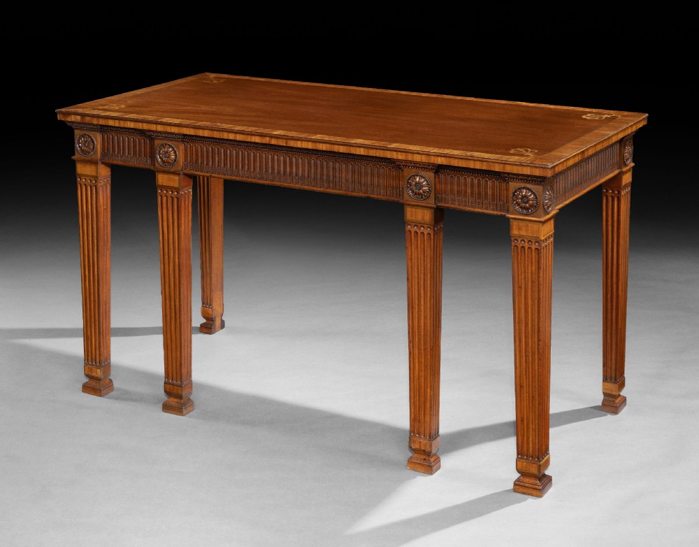 A rectangular George III mahogany console table featuring a fluted frieze, carved patera rosettes, corner inlay, and fluted square tapered legs. View II