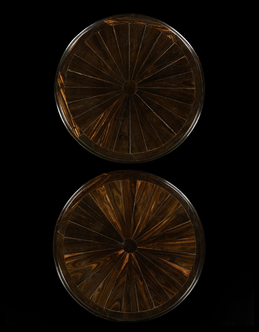 A pair of dark carved ebony tripod tables with radial inlaid circular tops and turned pedestals on scroll feet. View II