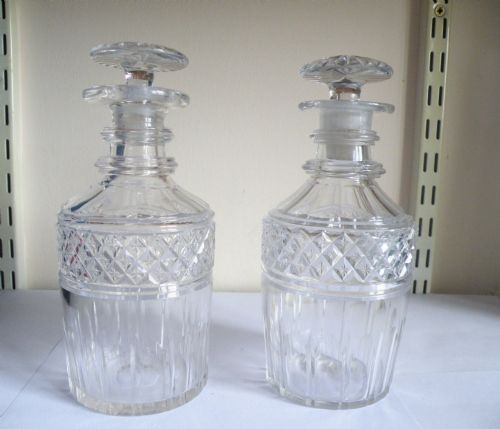 A PAIR OF GEORGIAN GLASS HALF BOTTLE OR SPIRIT DECANTERS