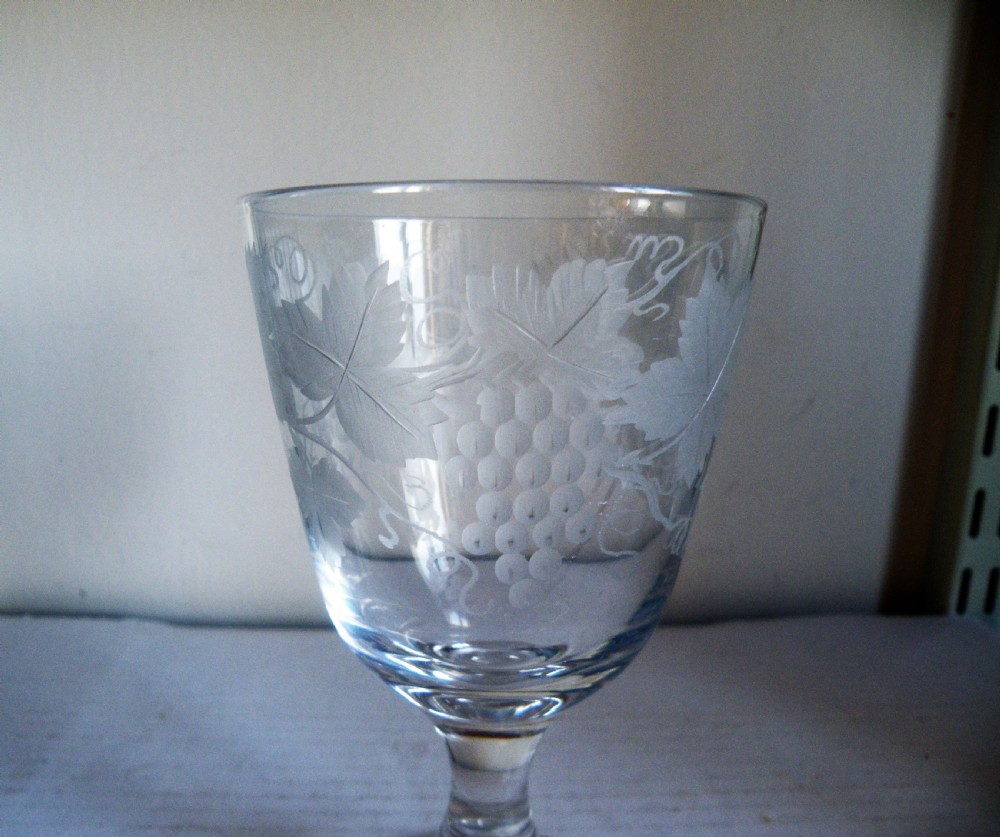 A clear Victorian glass goblet featuring wheel-engraved grapevine motifs around the bowl and a knopped stem on a flat round base. View III