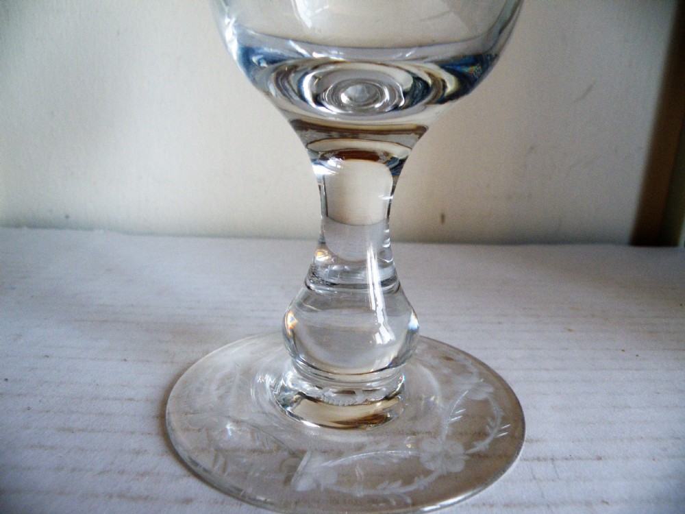 A clear Victorian glass goblet featuring wheel-engraved grapevine motifs around the bowl and a knopped stem on a flat round base. View IV