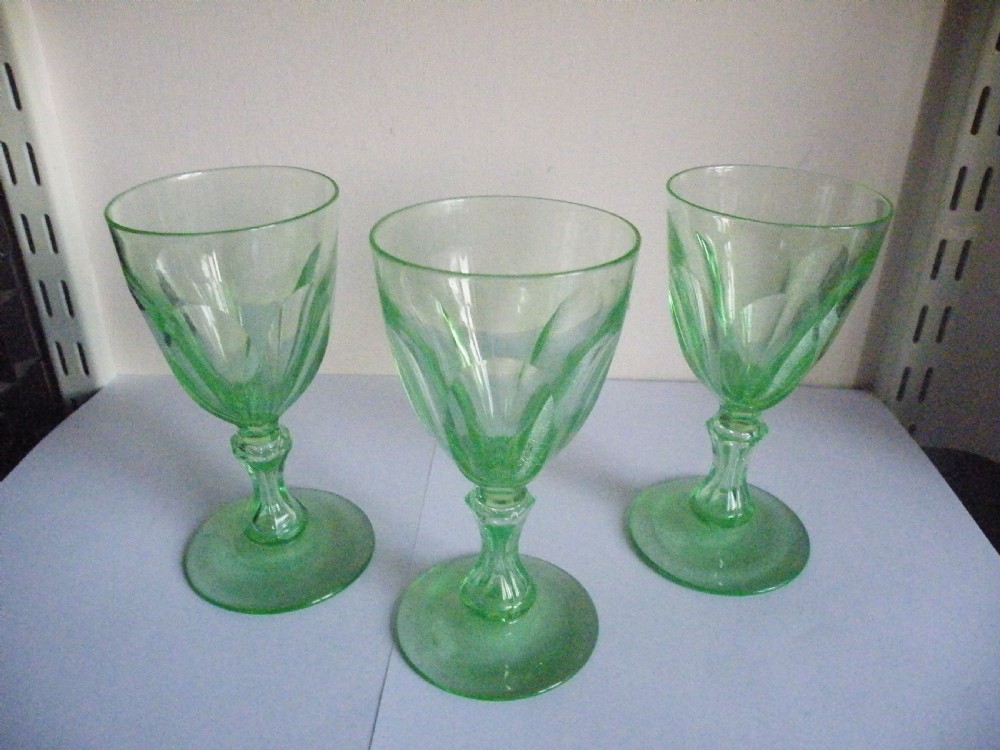 Three nineteenth-century light green vaseline glass wine glasses featuring panelled bowls and knopped stems. View II
