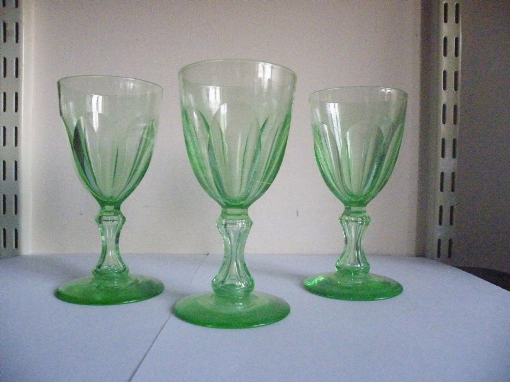 Three nineteenth-century light green vaseline glass wine glasses featuring panelled bowls and knopped stems. View III