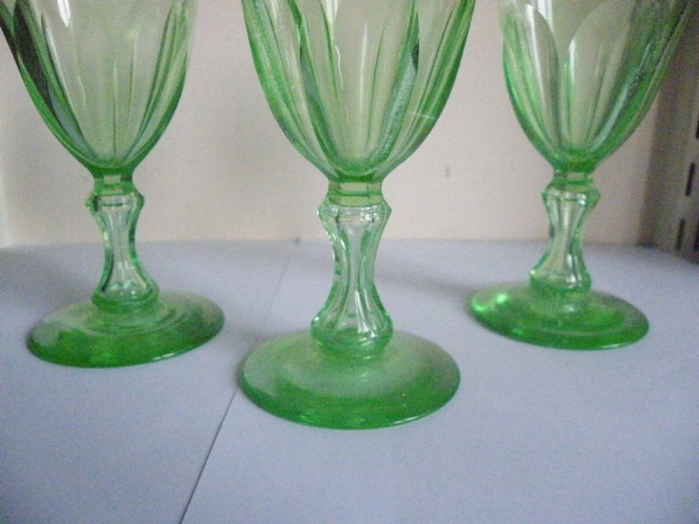 Three nineteenth-century light green vaseline glass wine glasses featuring panelled bowls and knopped stems. View IV