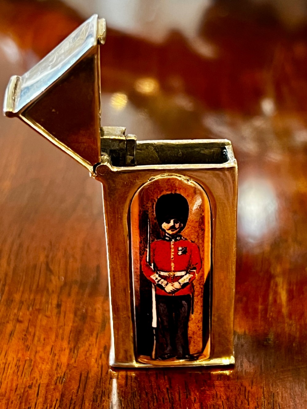A small vertical silver vesta case shaped like a sentry box, featuring a painted enamel depiction of a guardsman on the front. View VI