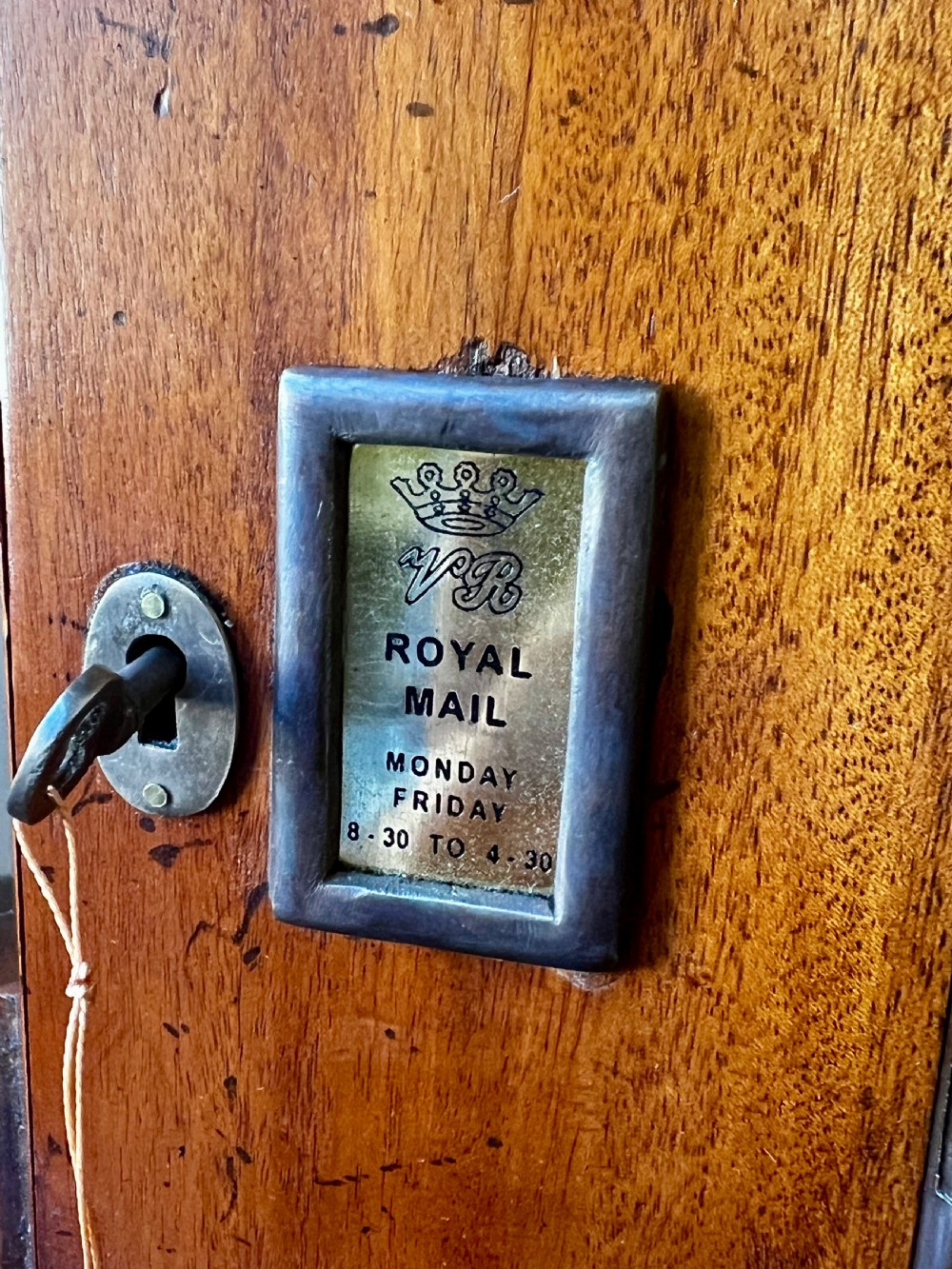 An octagonal wooden postal box featuring carved detailing on the domed roof, a brass letter slot, and a hinged locking door. View II