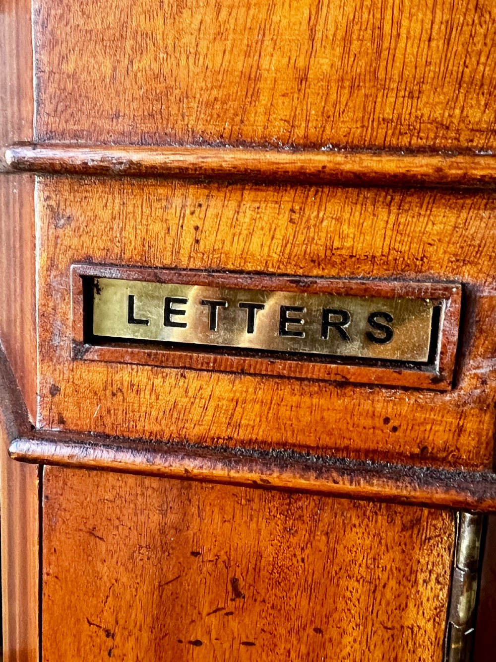 An octagonal wooden postal box featuring carved detailing on the domed roof, a brass letter slot, and a hinged locking door. View III