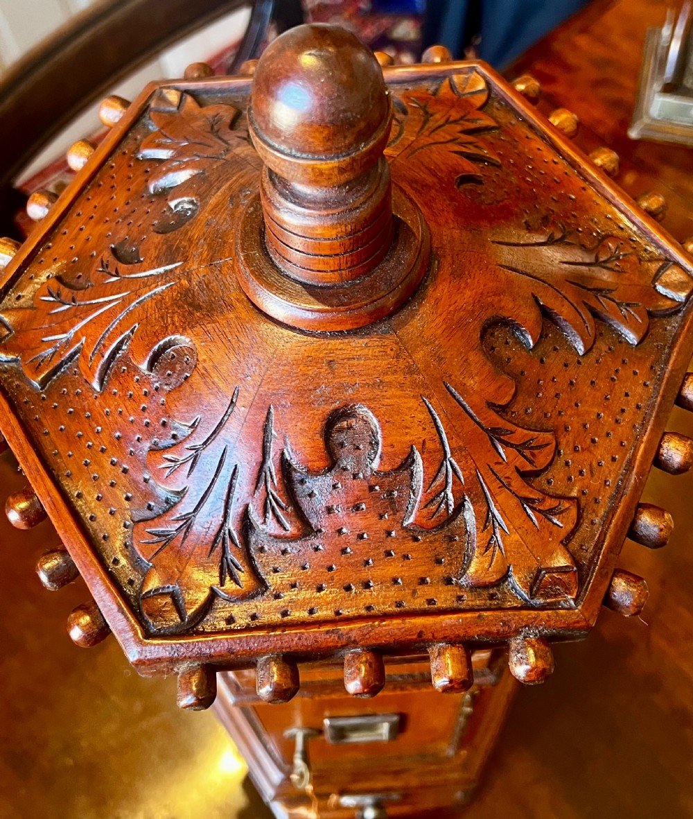 An octagonal wooden postal box featuring carved detailing on the domed roof, a brass letter slot, and a hinged locking door. View V