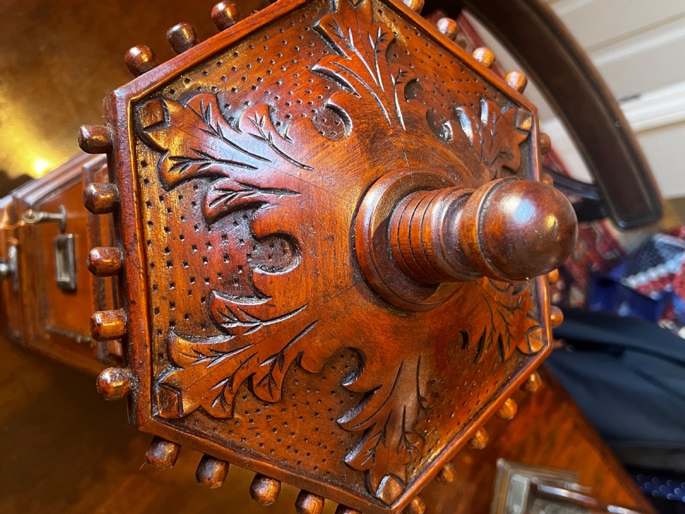 An octagonal wooden postal box featuring carved detailing on the domed roof, a brass letter slot, and a hinged locking door. View VI