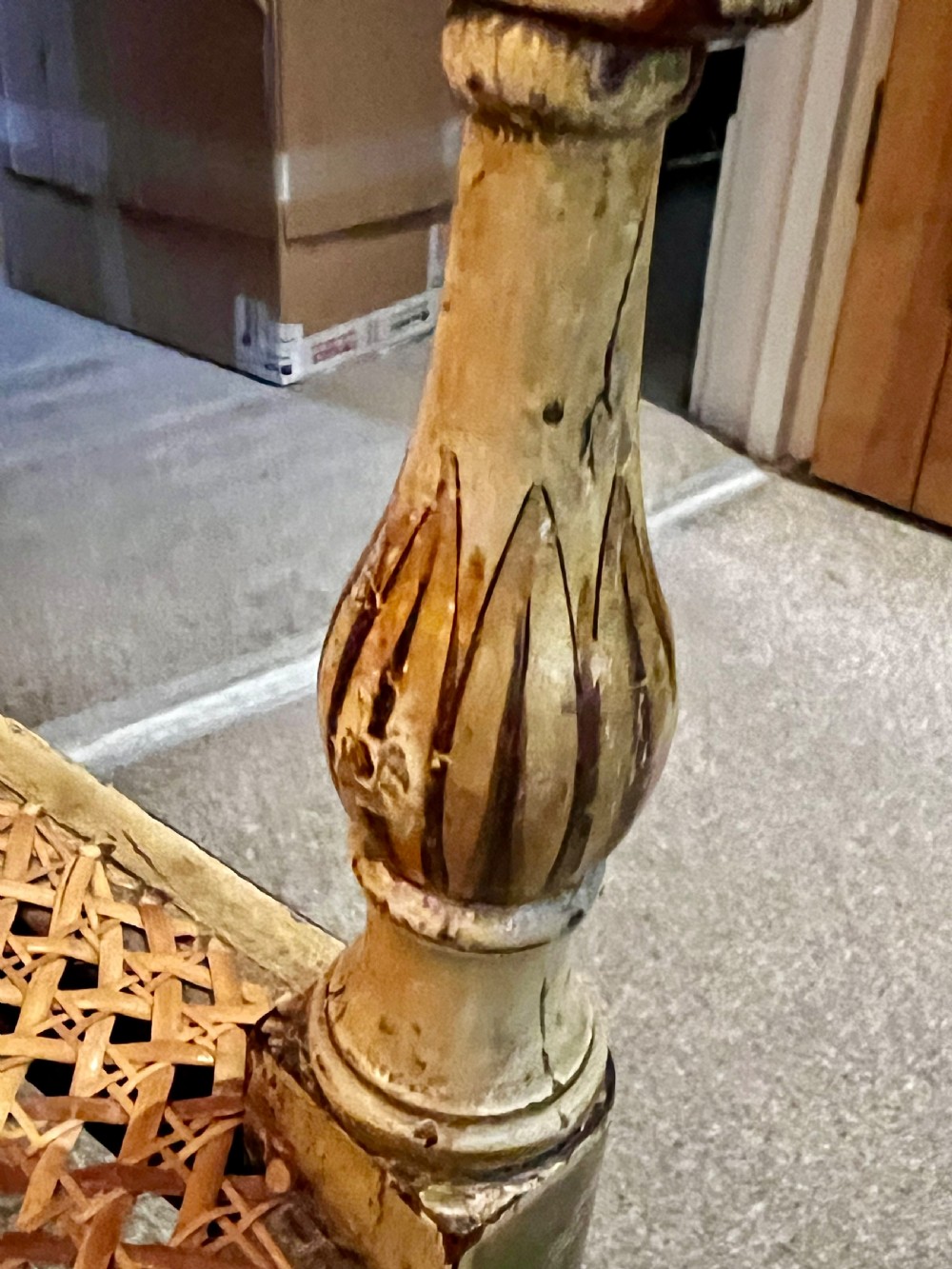 A Regency period cream painted elbow chair featuring hand-painted crest rail decoration, a geometric lattice back, sweeping arms, turned front legs, and a woven cane seat. View VII