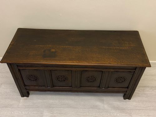 fig 4. An 18th-century dark oak coffer with a flat rectangular top and four recessed front panels resting on extended stile feet.