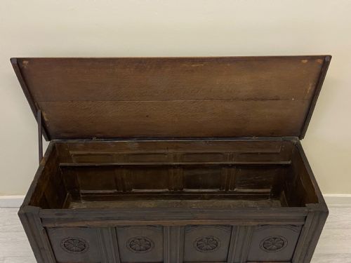 fig 5. An 18th-century dark oak coffer with a flat rectangular top and four recessed front panels resting on extended stile feet.