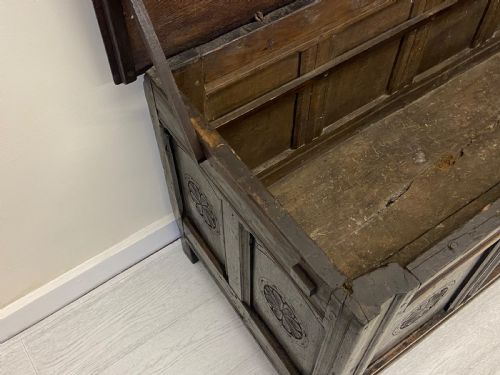 fig 7. An 18th-century dark oak coffer with a flat rectangular top and four recessed front panels resting on extended stile feet.
