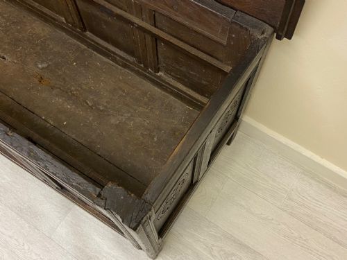fig 9. An 18th-century dark oak coffer with a flat rectangular top and four recessed front panels resting on extended stile feet.
