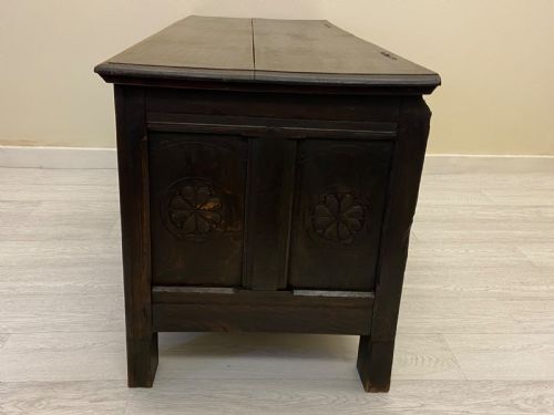 fig 10. An 18th-century dark oak coffer with a flat rectangular top and four recessed front panels resting on extended stile feet.