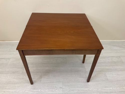 fig 6. An Edwardian mahogany fold-over tea table with straight tapered legs and a rectangular hinged top shown in a closed position against a plain neutral background.