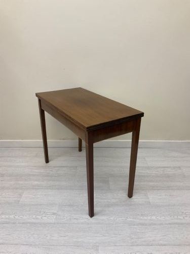 fig 1. An Edwardian mahogany fold-over tea table with straight tapered legs and a rectangular hinged top shown in a closed position against a plain neutral background.