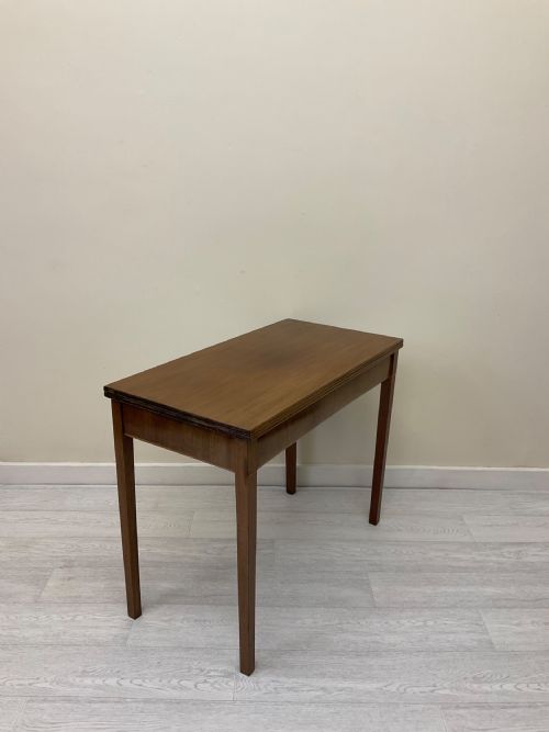 fig 5. An Edwardian mahogany fold-over tea table with straight tapered legs and a rectangular hinged top shown in a closed position against a plain neutral background.