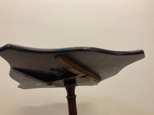 fig 3. A dark mahogany Victorian tilt-top side table resting on a turned central pedestal with three cabriole legs, shown with the top secured in the vertical position.