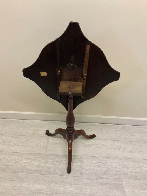 fig 7. A dark mahogany Victorian tilt-top side table resting on a turned central pedestal with three cabriole legs, shown with the top secured in the vertical position.