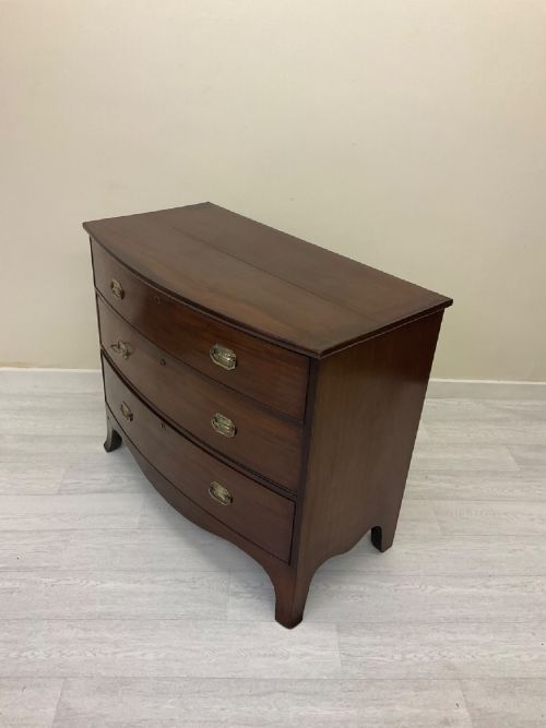 fig 1. A Victorian mahogany chest of drawers featuring three curved bow-front drawers, brass hardware, and shaped feet.