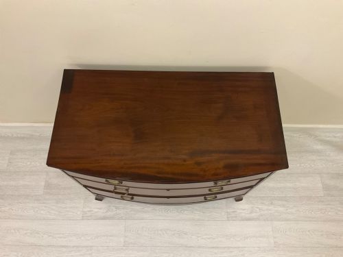 fig 2. A Victorian mahogany chest of drawers featuring three curved bow-front drawers, brass hardware, and shaped feet.