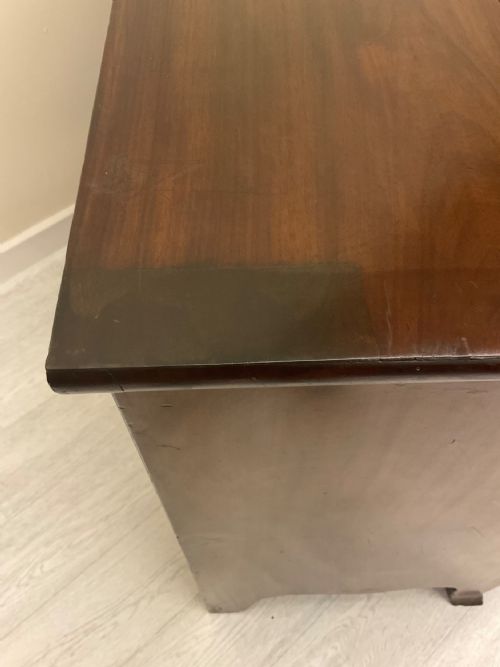 fig 6. A Victorian mahogany chest of drawers featuring three curved bow-front drawers, brass hardware, and shaped feet.