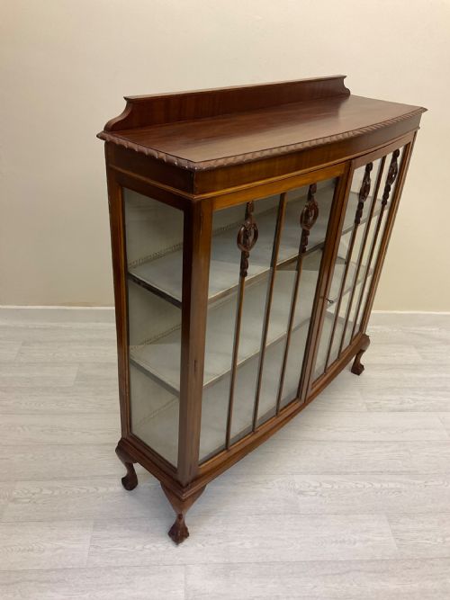 fig 5. An early 20th-century mahogany glazed display cabinet with decorative astragal glazing bars, cabriole legs, and ball-and-claw feet.