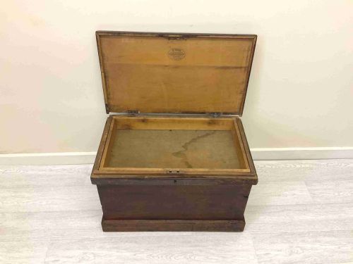 fig 3. A rectangular 19th-century Victorian pine trunk featuring a dark brown finish, hinged flat lid, central keyhole, and plinth base.
