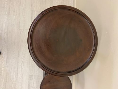 fig 3. A non-matching pair of dark brown mahogany plant stands featuring circular tops, lower undertiers, and curved legs.
