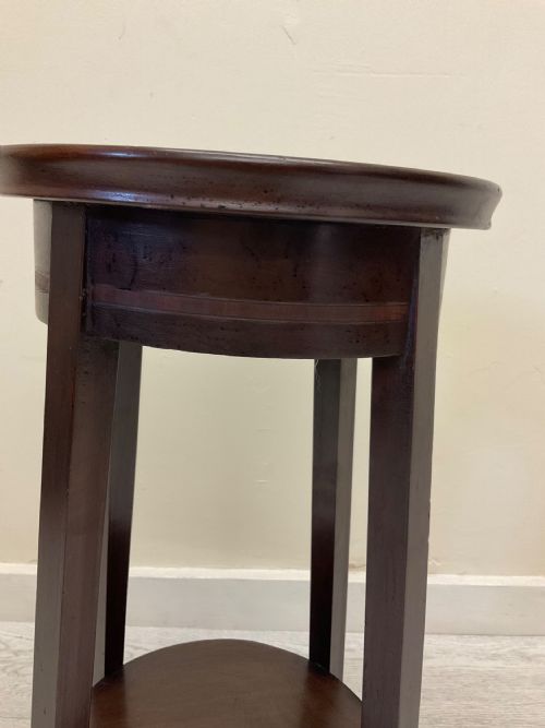 fig 1. A non-matching pair of dark brown mahogany plant stands featuring circular tops, lower undertiers, and curved legs.