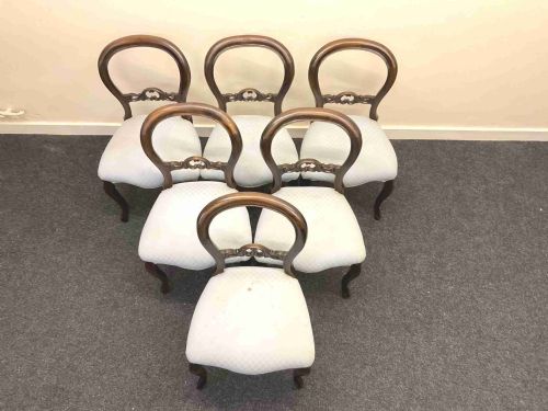 fig 2. A set of six Victorian mahogany dining chairs featuring rounded balloon backs, central carved splats, light blue upholstered seats, and cabriole front legs.