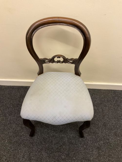 fig 3. A set of six Victorian mahogany dining chairs featuring rounded balloon backs, central carved splats, light blue upholstered seats, and cabriole front legs.