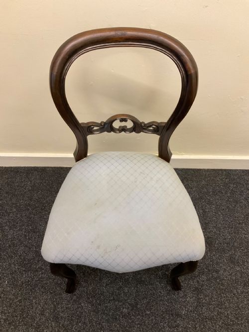 fig 4. A set of six Victorian mahogany dining chairs featuring rounded balloon backs, central carved splats, light blue upholstered seats, and cabriole front legs.