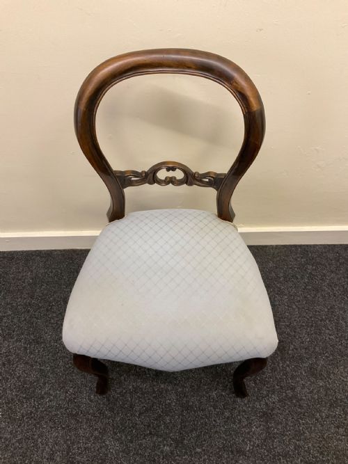 fig 5. A set of six Victorian mahogany dining chairs featuring rounded balloon backs, central carved splats, light blue upholstered seats, and cabriole front legs.