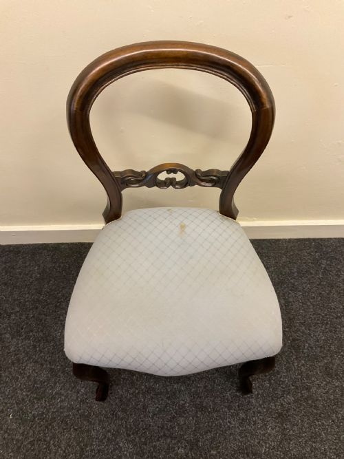 fig 7. A set of six Victorian mahogany dining chairs featuring rounded balloon backs, central carved splats, light blue upholstered seats, and cabriole front legs.